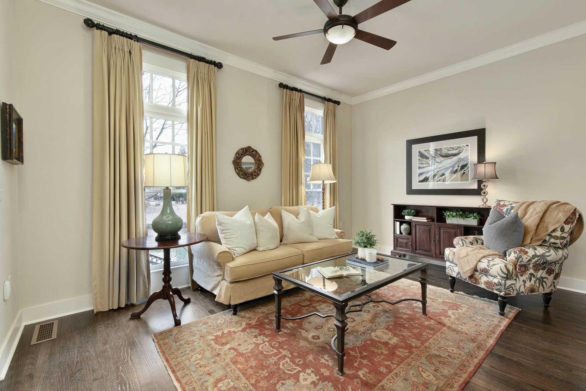 salon z kanapą fotelem dywanem zasłonami i lampami