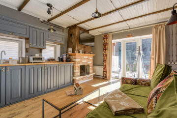 salon z kuchnią kominkiem i etnicznymi dodatkami