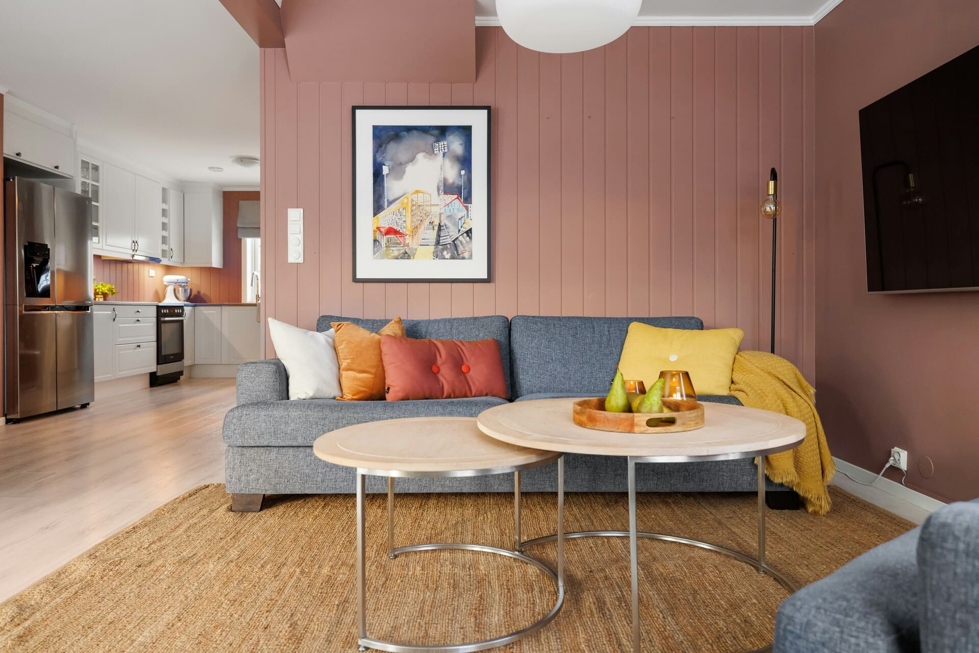 pastelowe wnętrze salon z kuchnią szara sofa stoliki drewniane