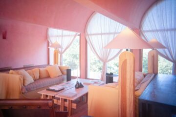 wnętrze salonu z różowymi ścianami i beżowymi meblami