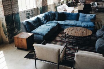 salon z różnymi sofami stolik drewniany industrialne wnętrze